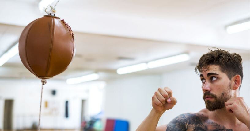 Ein Mann trainiert mit einer Boxbirne im Fitnessstudio