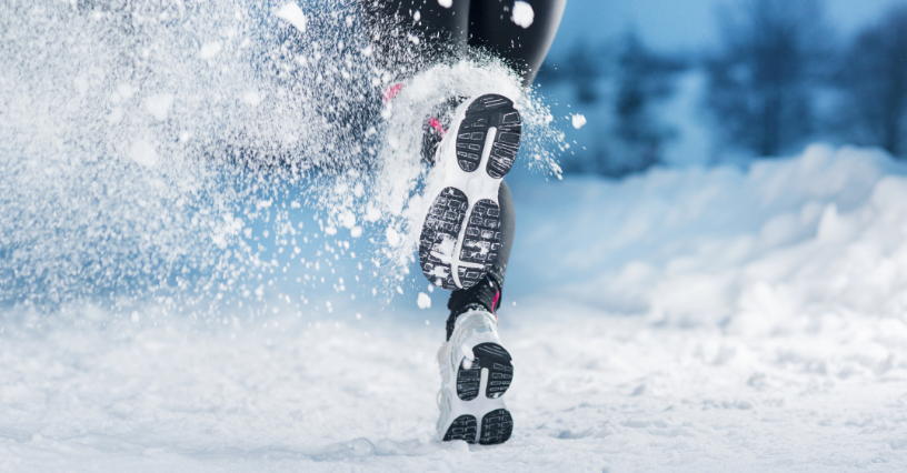 Person läuft im Schnee mit Sportschuhen