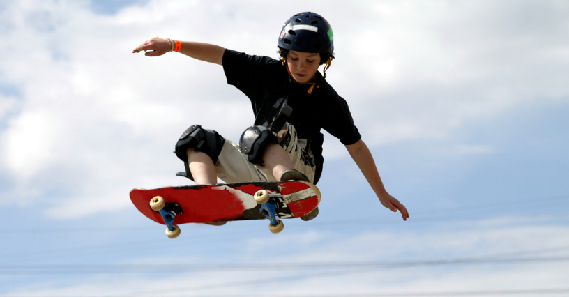 Ein Skateboarder springt mit einem roten Board in die Luft