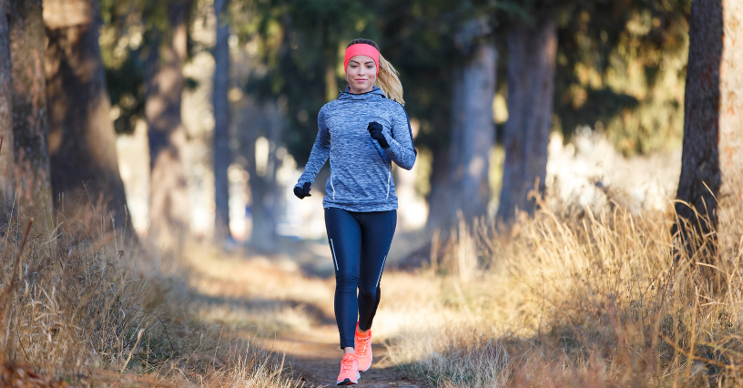 Eine Frau joggt auf einem Waldweg