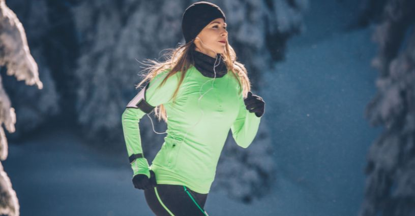 Eine Frau joggt auf einem verschneiten Pfad