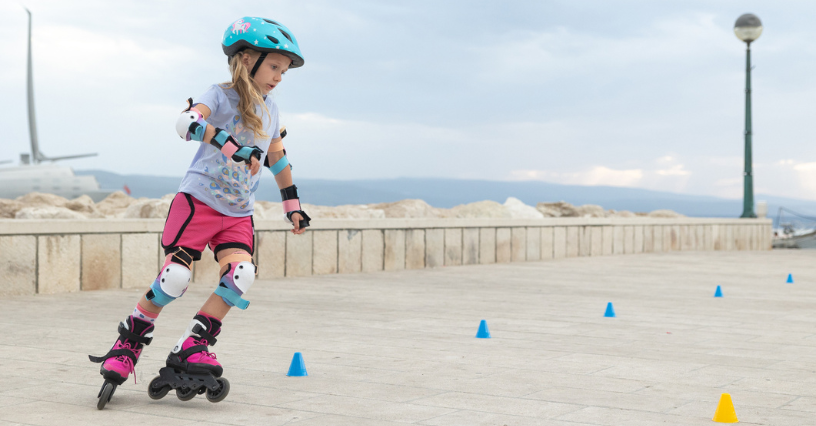 Ein Kind übt Inline-Skaten mit Schutzausrüstung