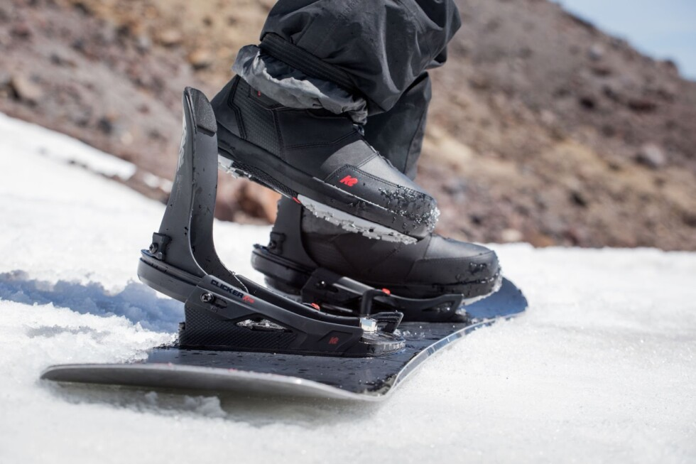 Snowboardbindung mit Schuhen im Schnee befestigt