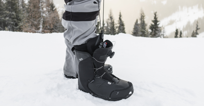 Eine Person trägt Snowboardstiefel im Schnee