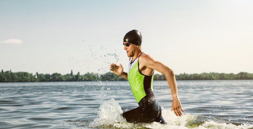 Ein Mann läuft aus dem Wasser, bereit für die nächste sportliche Herausforderung
