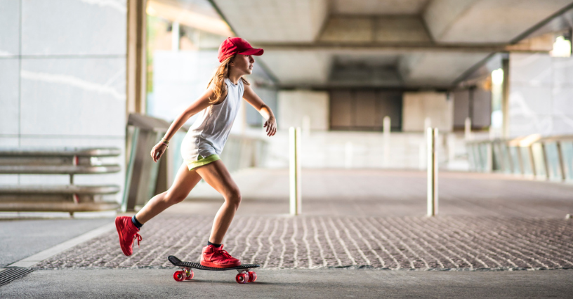 Ein Kind fährt auf einem Skateboard in einem urbanen Bereich