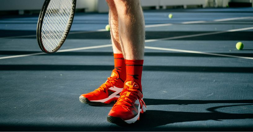 Ein Tennisspieler trägt rote Schuhe auf dem Tennisplatz