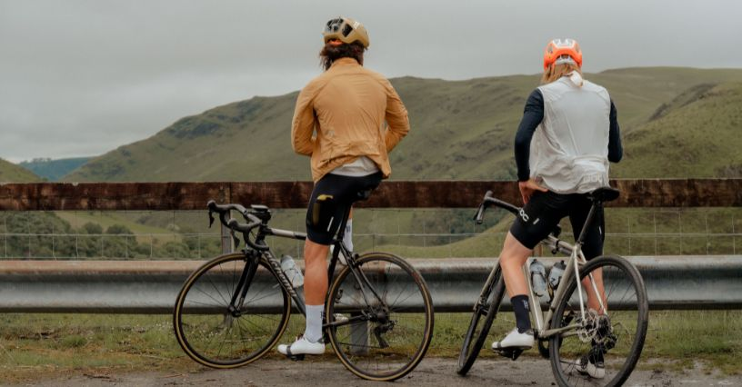 Zwei Radfahrer machen eine Pause mit Blick auf die Berge