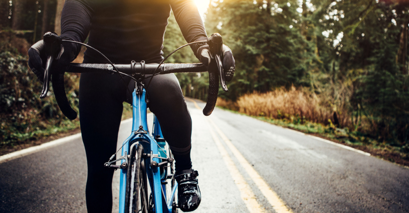 Eine Person fährt auf einem Rennrad auf einer Landstraße