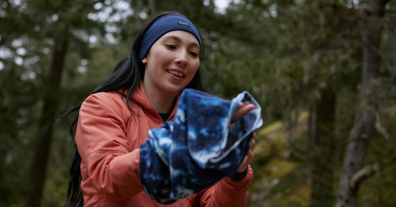 Eine Frau hält ein Sportkleidungsstück im Freien