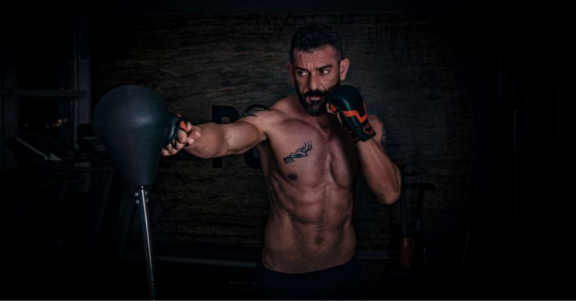 Ein Mann trainiert Boxen mit einem Punchingball im Fitnessstudio