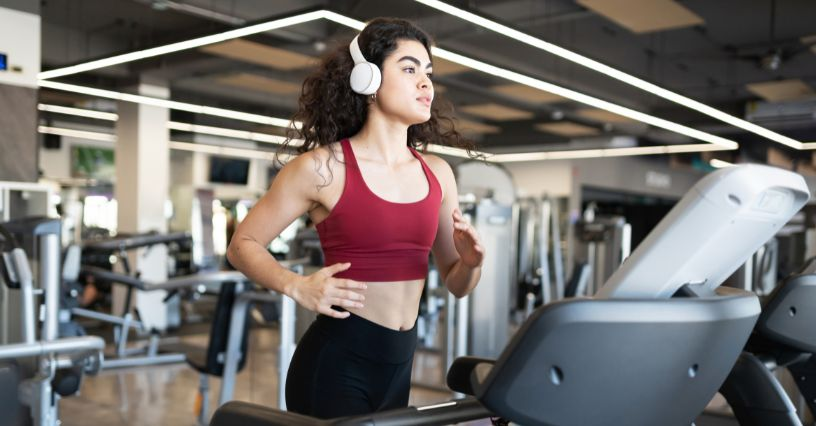 Eine Frau joggt auf dem Laufband im Fitnessstudio