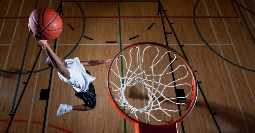 Ein Basketballspieler macht einen Korbleger in der Halle