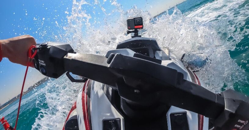 Eine Sportkamera ist auf einem Jetski montiert und filmt während der Fahrt durch das Wasser