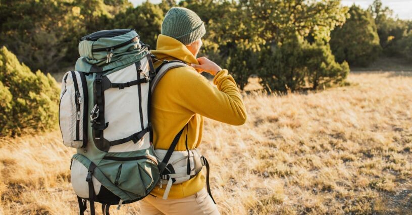 Person wandert mit einem großen Rucksack in den Bergen