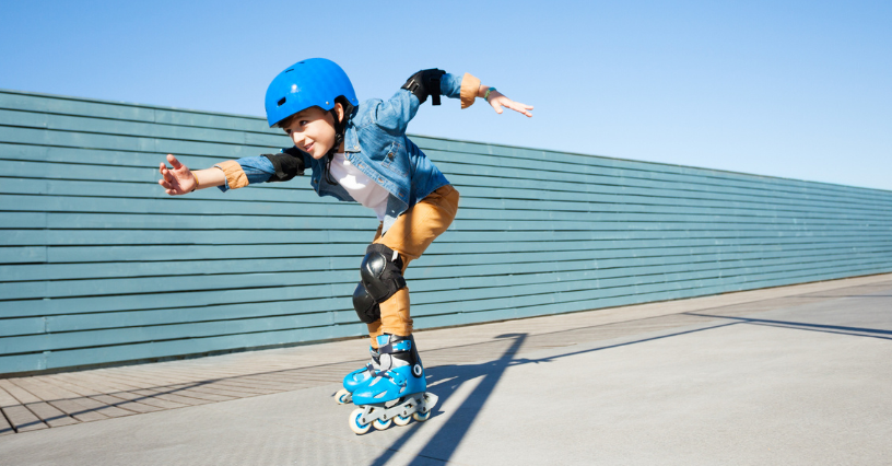 Ein Kind fährt auf Inlineskates mit Schutzkleidung