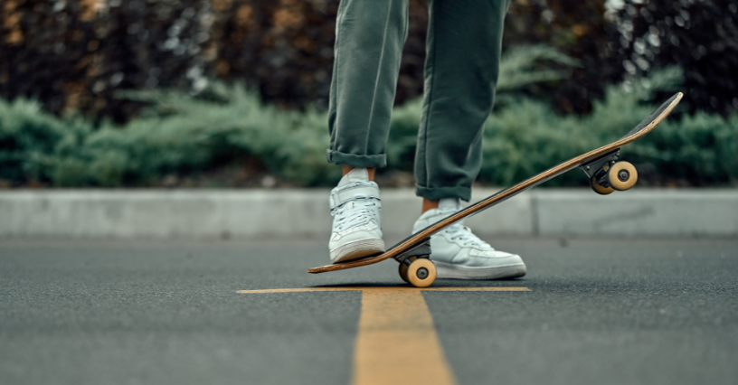 Eine Person balanciert auf einem Skateboard auf der Straße