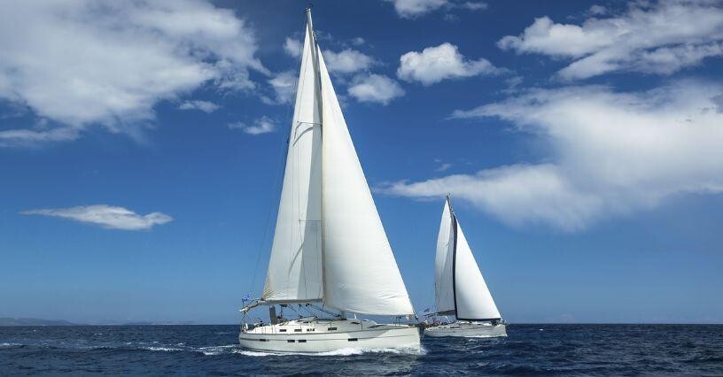 Zwei Segelboote segeln auf offenem Meer unter blauem Himmel