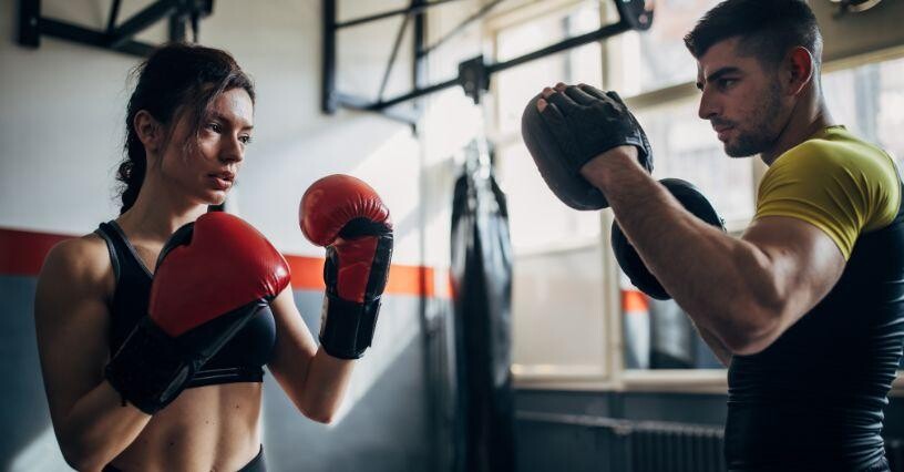 Zwei Personen trainieren Boxtechniken im Fitnessstudio